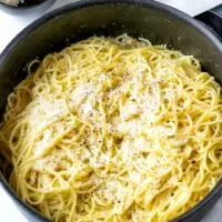 Cacio e Pepe in a large pot, garnished with extra vegan parmesan.