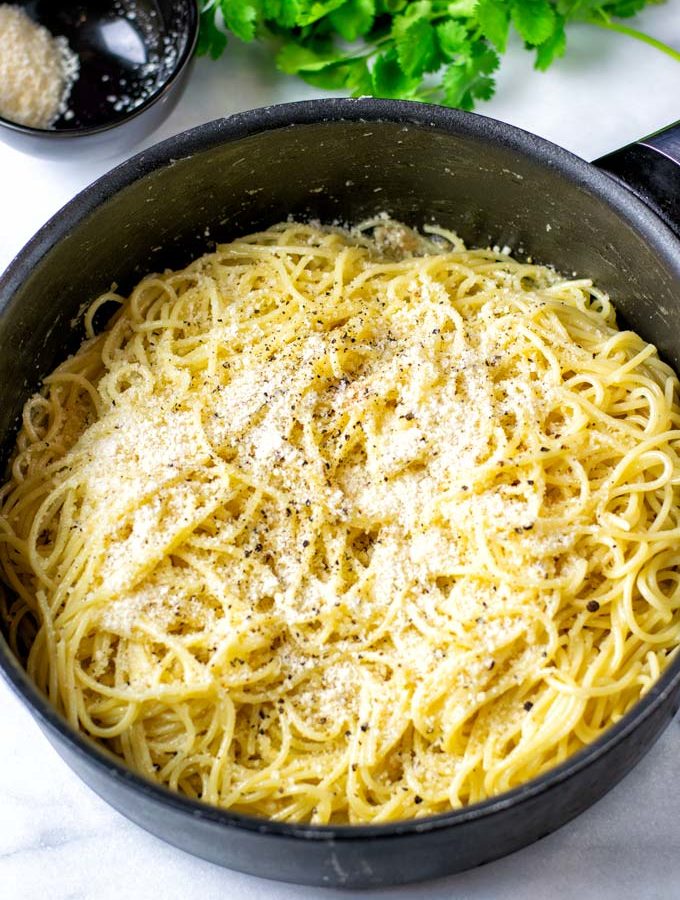 Cacio e Pepe in a large pot, garnished with extra vegan parmesan.