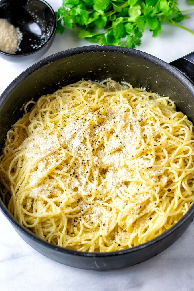 Cacio e Pepe in a large pot, garnished with extra vegan parmesan.