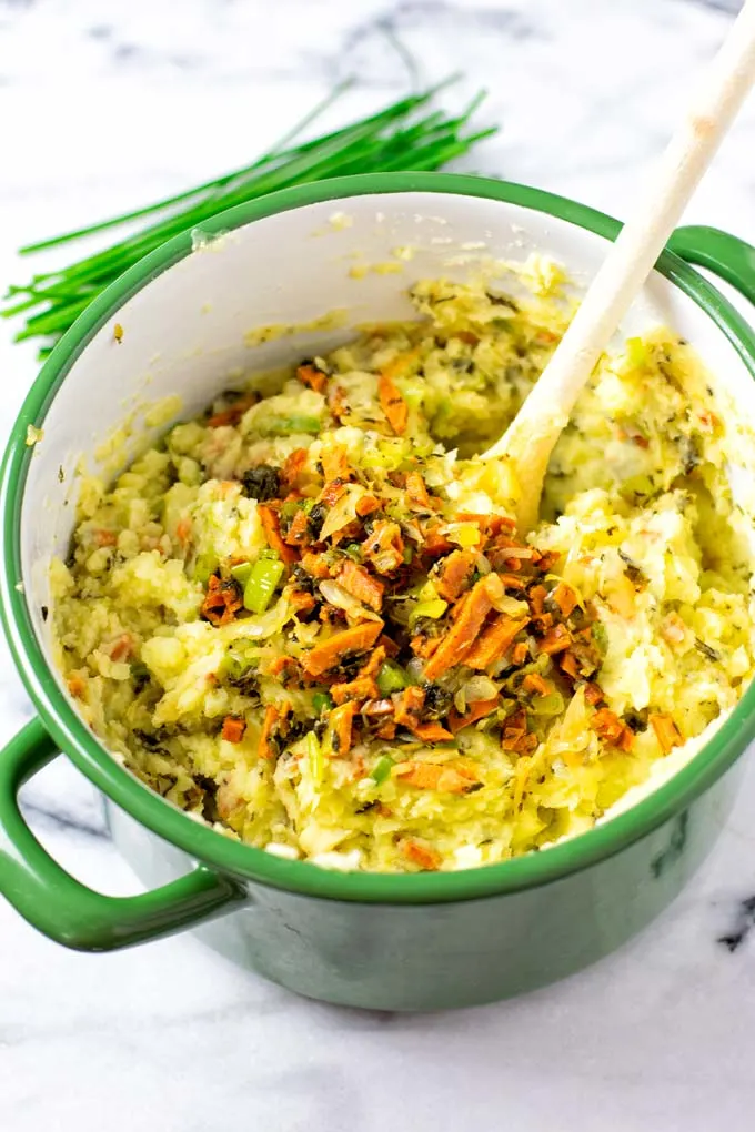 Ready Colcannon in a large pot with a wooden spoon.