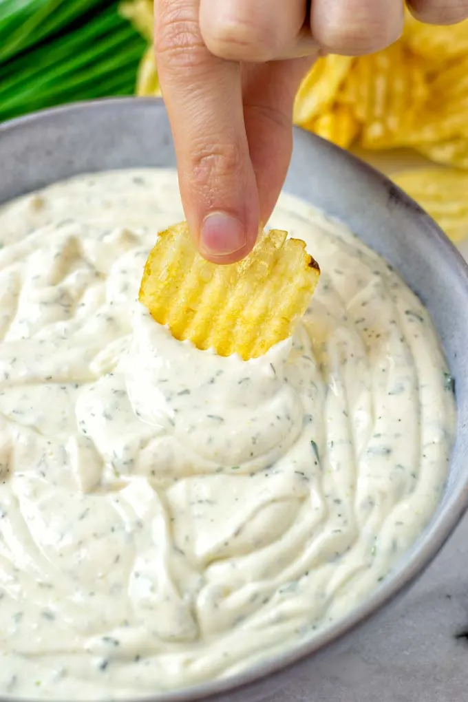 Dipping a potato chip into the dip.