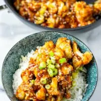 Sweet and Sour Cauliflower server over rice in a blue bowl.