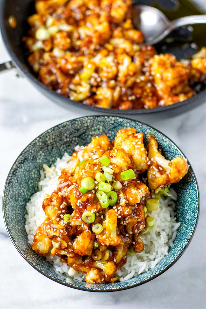 Sweet and Sour Cauliflower server over rice in a blue bowl.