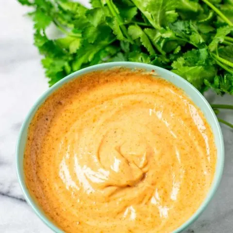 The ready Cajun Sauce in a bowl with fresh parsley in the background.