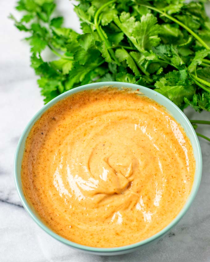 The ready Cajun Sauce in a bowl with fresh parsley in the background.