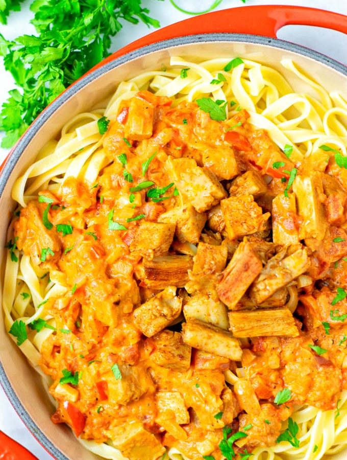 Top view on a sauce pan full with Paprikash served over pasta.