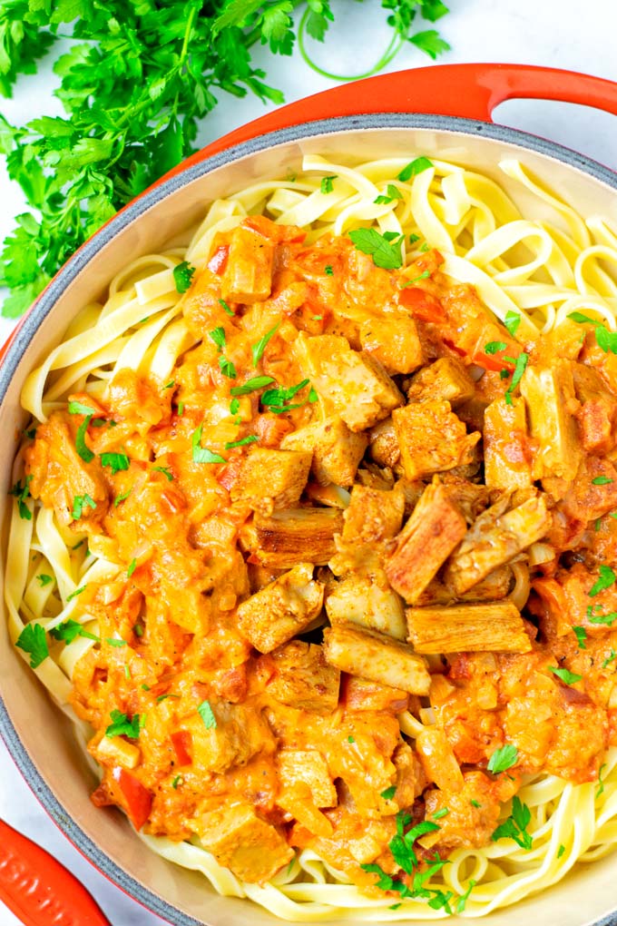 Top view on a sauce pan full with Paprikash served over pasta.