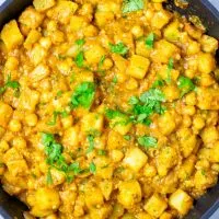 View from above on the frying pan filled with the Potato Curry, garnished with cilantro.