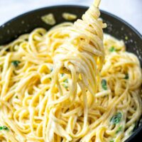 Lemon Pasta rolled on a golden fork, lifted out of the pan.