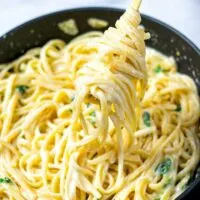 Lemon Pasta rolled on a golden fork, lifted out of the pan.