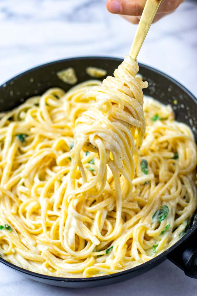 Lemon Pasta rolled on a golden fork, lifted out of the pan.