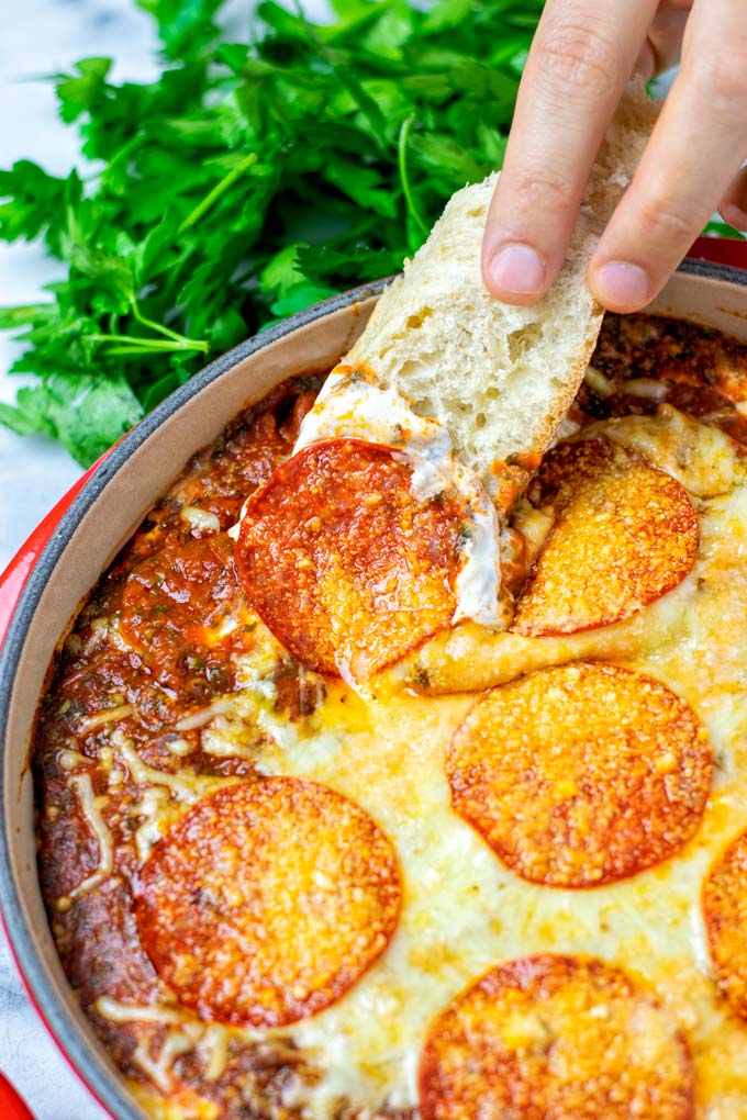 Dipping some bread into the vegan Pizza Dip.