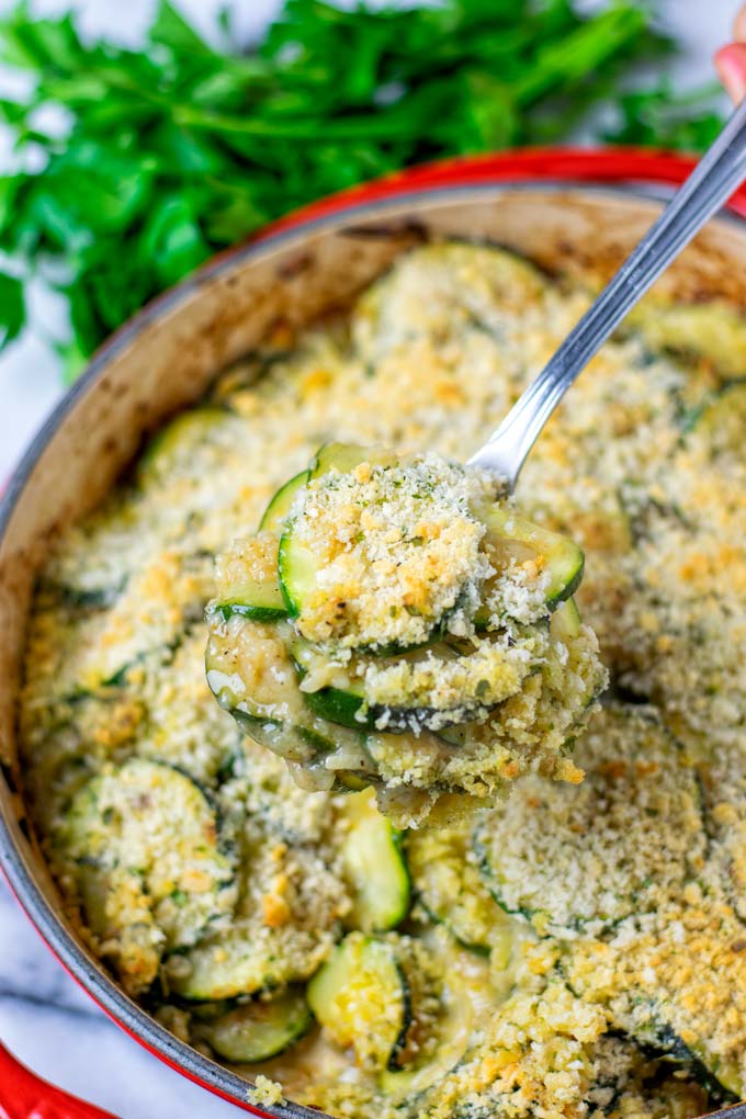 A portion of the Zucchini Casserole is lifted out of the pan with a spoon.