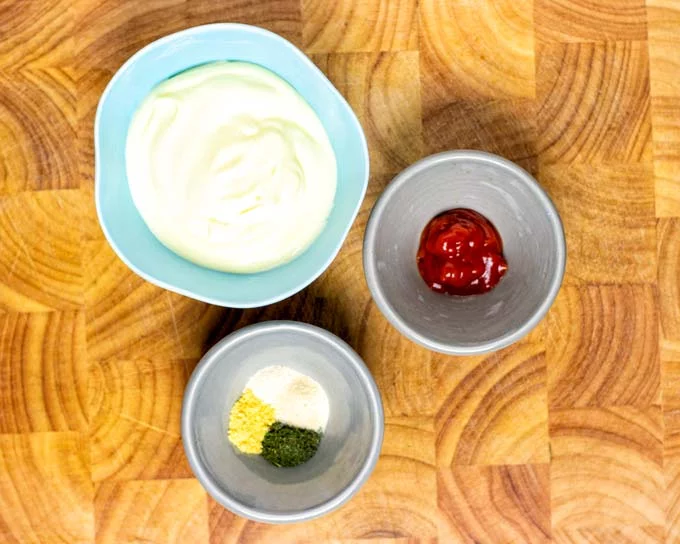 Ingredients for this recipe prepared in small bowls on a wooden board.