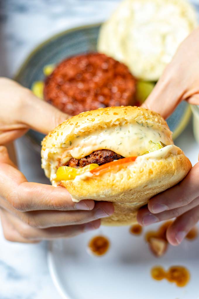 A burger is held in two hands.