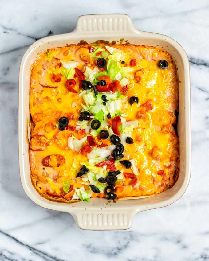 The ready Taco Casserole is garnished with fresh lettuce, jalapenos, and black olive slices. 