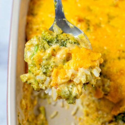 Broccoli Rice Casserole is lifted from the dish on a large spoon.