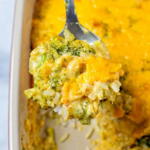 Broccoli Rice Casserole is lifted from the dish on a large spoon.