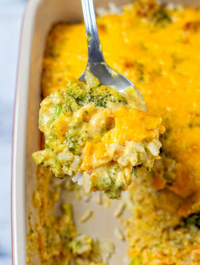Broccoli Rice Casserole is lifted from the dish on a large spoon.