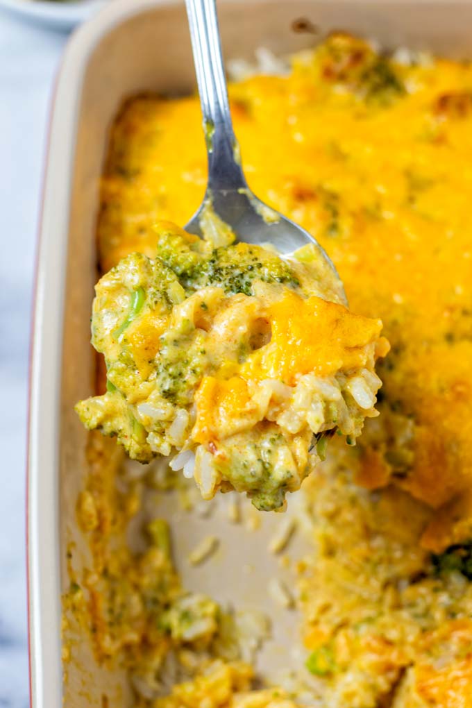 Broccoli Rice Casserole is lifted from the dish on a large spoon.