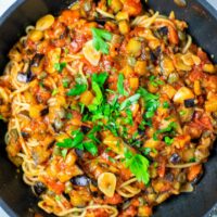 Top view of the Pasta alla Norma in a saucepan, garnished with parsley.