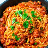 Fresh parsley is used as garnish over the spaghetti.