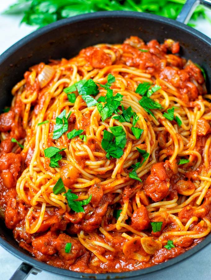 Fresh parsley is used as garnish over the spaghetti.