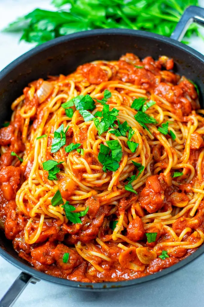 Fresh parsley is used as garnish over the spaghetti.