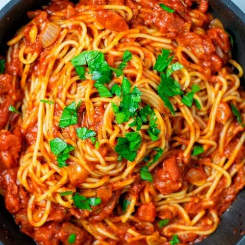 Top view on the Spaghetti Sauce mixed with pasta in a pan.