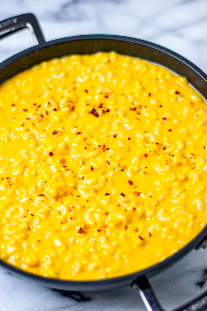 Stovetop Mac and Cheese seasoned with chili flakes in a large saucepan.