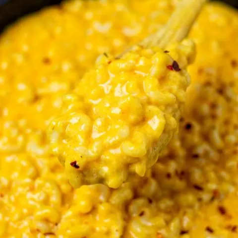 A view on the Stovetop Mac and Cheese being lifted from the pan with a spoon.