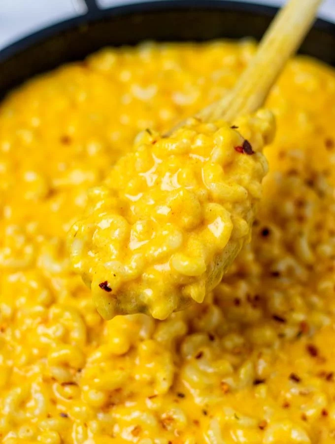 A view on the Stovetop Mac and Cheese being lifted from the pan with a spoon.