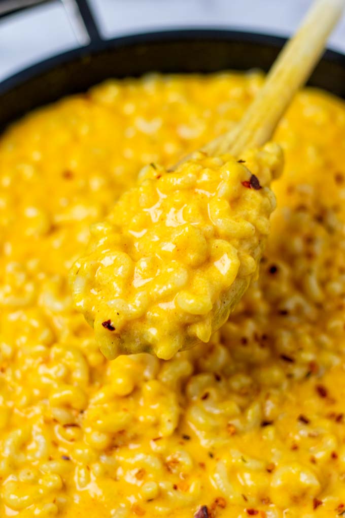 A view on the Stovetop Mac and Cheese being lifted from the pan with a spoon.