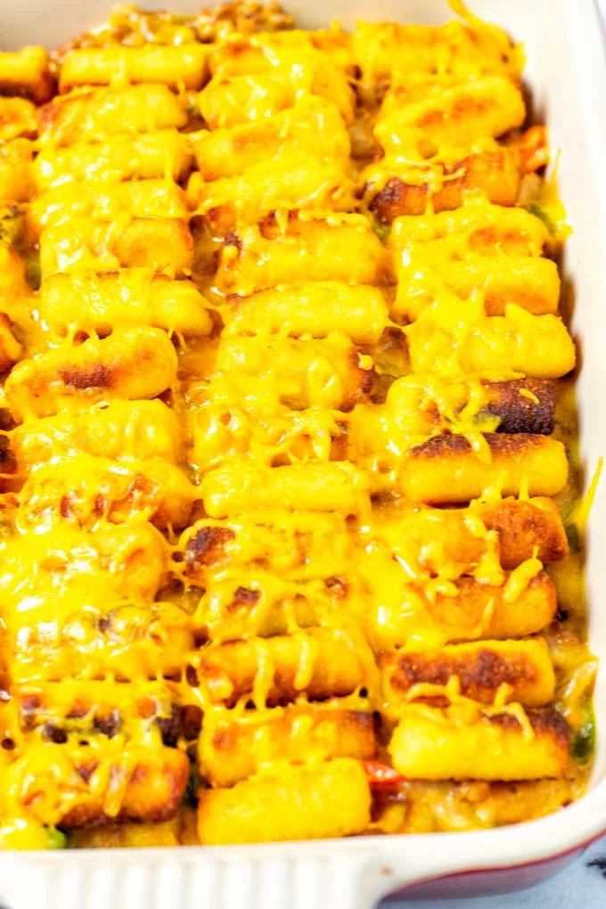Closeup of the Tater Tot Casserole after baking, with melted vegan cheddar on top.