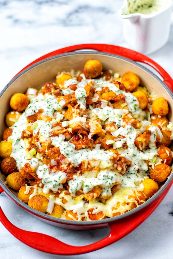 The casserole dish with the Totchos covered with Ranch Dressing. 