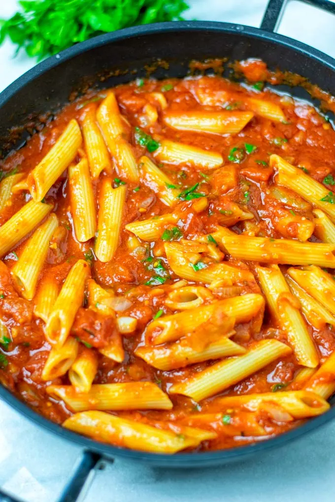 Cooked pasta is mixed with the Arrabbiata Sauce in the saucepan.