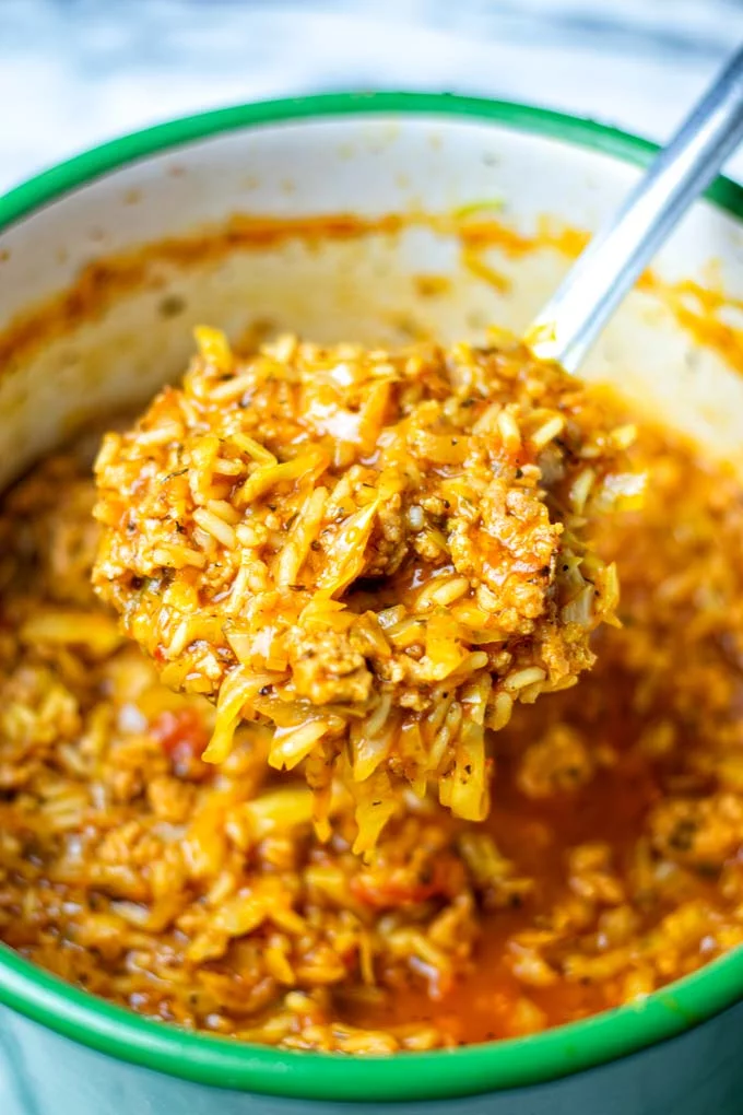 A large spoonful of the Cabbage Roll Soup is taken out of the pot.