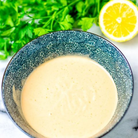 Ready Marie Rose Sauce in a bowl with parsley and a lemon in the background.