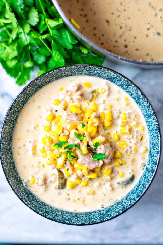 Pot view on a portion of the Corn Soup showing clearly the corn, vegan ground beef, jalapeno slices and creamy liquid.