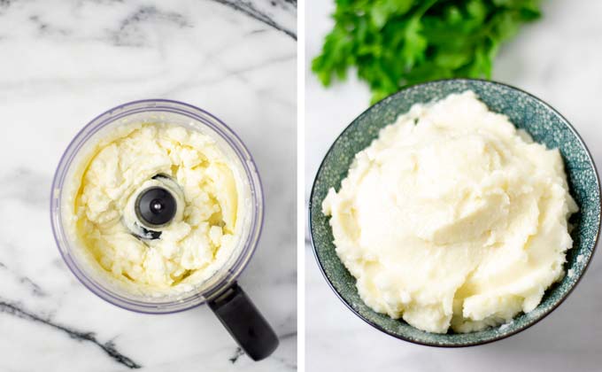 The ready Garlic Sauce in the food processor and transferred to a blue serving bowl with some fresh herbs in the background.