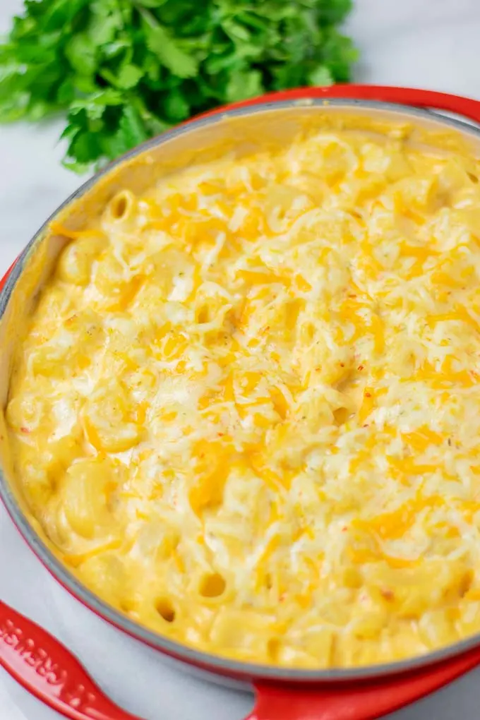 Southern Mac and Cheese after baking fresh from the oven, with some fresh herbs in the background.