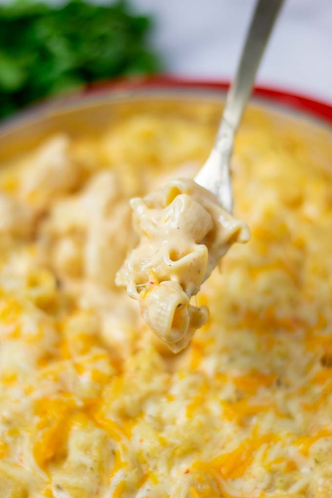 A fork lifts some Mac and Cheese from the casserole.