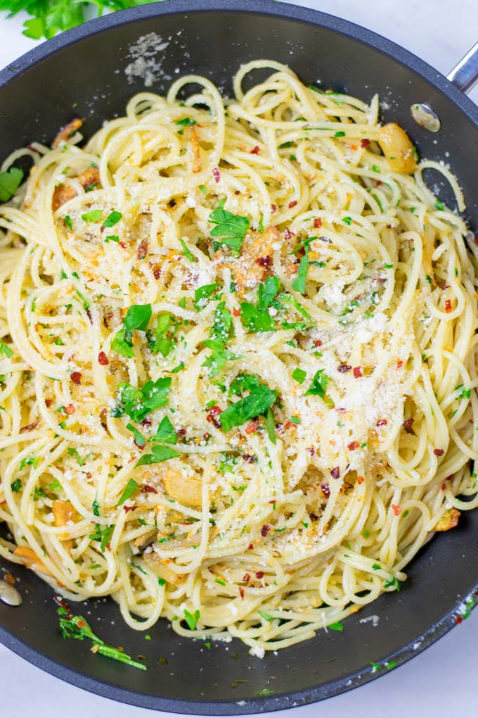 Top view of the Spaghetti aglio e olio with extra vegan Parmesan and herbs.