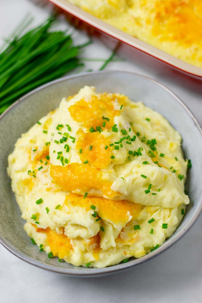 Large portion of the Creamy Potatoes on a grey plate, garnished with fresh chives.