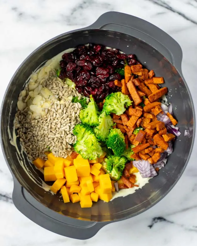 Top view of a large bowl with all ingredients of the Broccoli Salad.