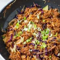 The Egg Roll in a Bowl garnished with scallions in a pan.