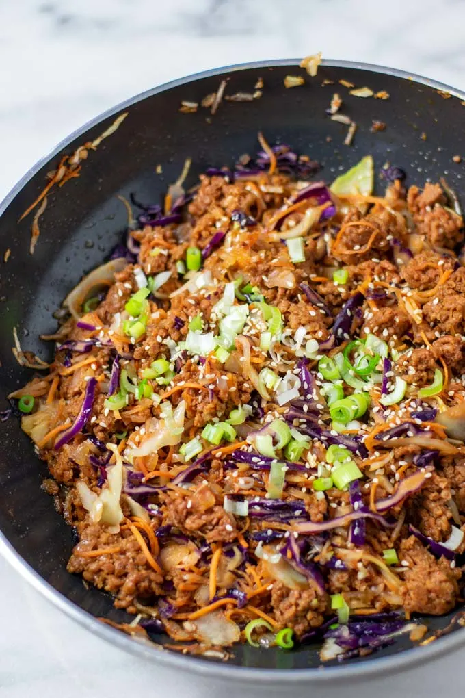 The Egg Roll in a Bowl garnished with scallions in a pan.