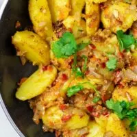 Top view on the ready Bombay Potatoes in a large pan.