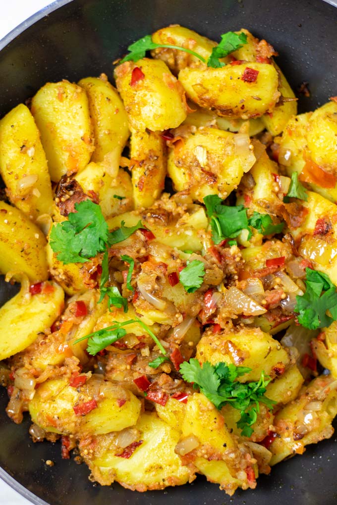 Top view on the ready Bombay Potatoes in a large pan.