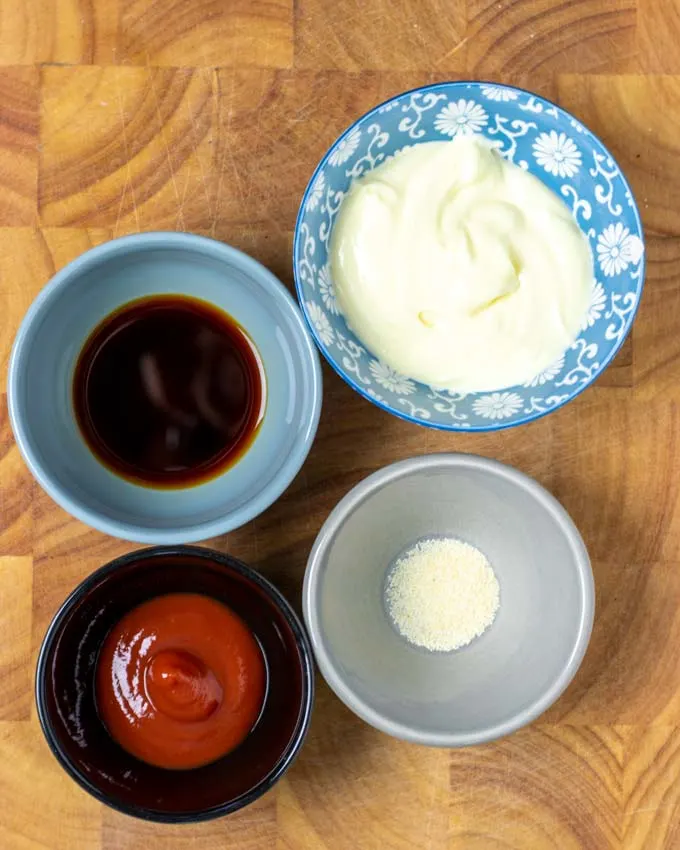 Ingredients for the Cane's Sauce assembled on a wooden board.